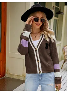 Detail of preppy brown V-neck cardigan with letter B patch and striped sleeves.