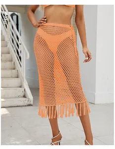 Detalle de la falda midi naranja de ganchillo con flecos largos y cordón en la cintura.