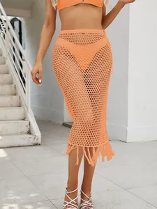 Elegante falda midi de ganchillo naranja con flecos y diseño calado para el verano.