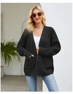 Detail eines übergroßen schwarzen Cardigans mit Waffelstrickmuster und großen Taschen
