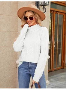 Detailed street style view of white cable-knit turtleneck sweater for women on model