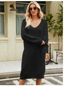Close-up detail of a black oversized V-neck knit sweater dress with a textured pattern