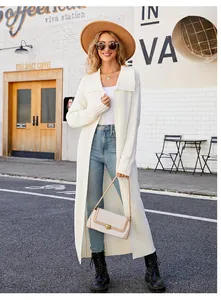 Fashionable model wearing a long white knit cardigan with lapel on a sunny city street