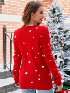 Red Christmas knit sweater with white dots worn by woman in festive setting