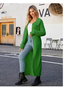 Full body view of a long green lapel knit cardigan in an urban street setting