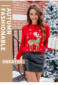 Détail du pull de Noël rouge avec broderie de renne dorée et motifs flocons de neige