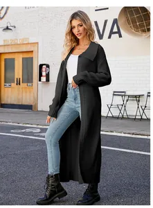 Full-length view of a black oversized knit cardigan on a model in a street setting