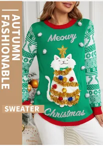 Détail d'un pull de Noël vert avec texte en paillettes et broderie chat
