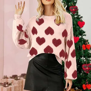Close-up detail shot of pink puff sleeve sweater featuring a red heart jacquard pattern.