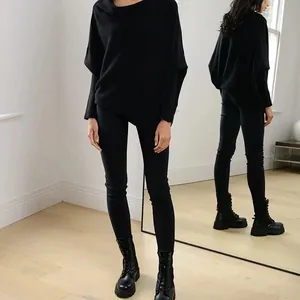 Elegant black boat-neck batwing sleeve knitted sweater shown with mirror back reflection