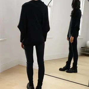 Detailed back view of a black boat neck batwing sleeve knit sweater with mirror reflection.
