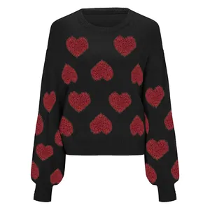 Close-up detail of black knit sweater with red heart jacquard and bubble sleeves