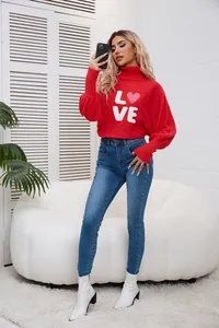 Vista dettagliata di un maglione rosso a collo alto con scritta LOVE e cuore rosa.