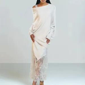 Detailed view of elegant white off-shoulder knit dress featuring intricate lace hemline