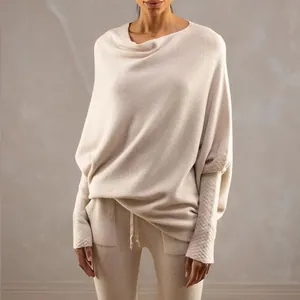 Close-up detail of a soft cream boat neck knit pullover with loose batwing sleeves design