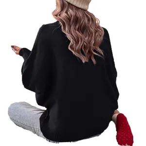 Elegante maglione oversize nero con maniche a pipistrello visto da dietro in posa seduta