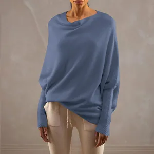 Detail view of a loose blue boat neck sweater with batwing sleeves and ribbed cuffs.