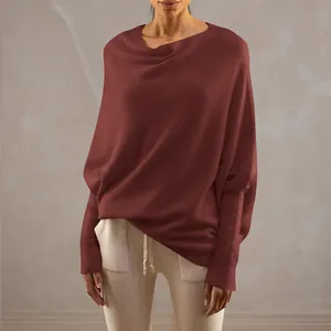 Detail shot of a loose batwing sleeve knit pullover with a solid brick red finish