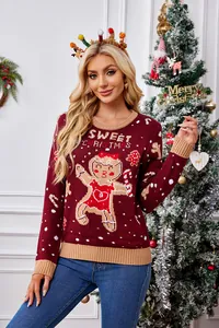 Detail van een bordeauxrode kersttrui met peperkoekmannetje patroon en tekst