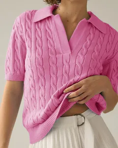Close-up of pink short-sleeve polo knit sweater featuring classic cable pattern