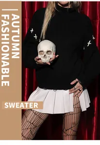 Detail of black oversized Halloween sweater with laced sleeves and skull prop accessory.