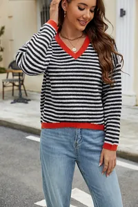 Detailed view of striped V-neck knit sweater with red contrast trim and soft texture