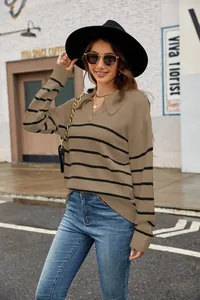 Pull en maille rayé décontracté à col polo beige et noir dans un décor de rue extérieur