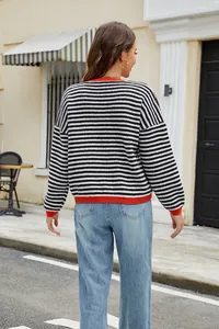 Back view of a black and white striped knit sweater with vibrant orange ribbed trim
