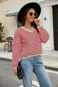 Outdoor shot of a casual red and white striped V-neck knit sweater with beige ribbed trim