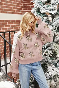 Gemütlicher rosa Weihnachtspullover mit Rentier-Muster in verschneiter Außenszene