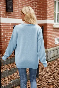 Back view of a light blue oversized knitted sweater with 3D floral sleeve details.