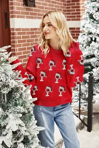 A detailed view of a festive red Christmas sweater with sparkling holiday hat patterns.