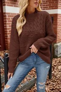 Close-up view of chocolate cable-knit sweater texture and openwork detailing.