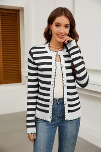 Modelo luciendo una chaqueta de punto de rayas blancas y negras con botones metálicos