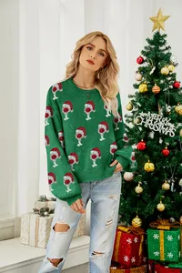 Woman wearing festive green Christmas pullover with cute Santa hat patterns by a tree