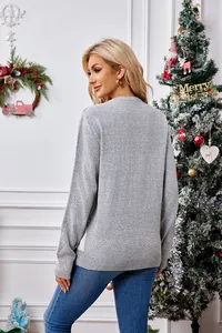 Detailed back view of a casual loose grey knitted Christmas sweater in a festive home setting