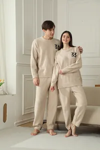 Couple lounging in comfortable beige plush pajama sets with number 33 embroidery detail