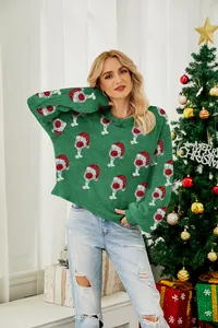 Detailed view of a green Christmas sweater with Santa hat wine glass patterns