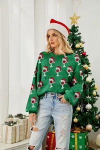 Detail view of a green Christmas sweater with sparkling wine glass and hat patterns