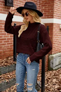 Stylish maroon cable-knit sweater for autumn, worn with a black hat and jeans
