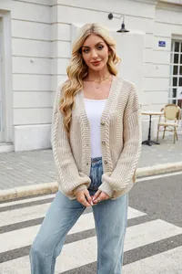 Close-up detail of beige oversized cable-knit cardigan with V-neck and button closure