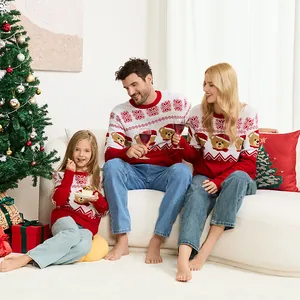 Familia con suéteres navideños rojos a juego con jacquard de osos en ambiente festivo.