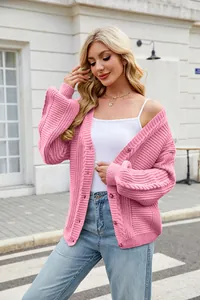 Detailed shot of a stylish pink oversized cable-knit cardigan with V-neckline for women