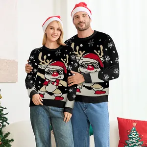 Stel draagt bijpassende zwarte kersttruien met dabbing rendier en kerstmutsen in huis.