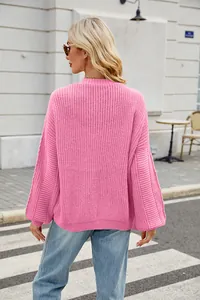 Back view of pink oversized knit cardigan showing detailed textured stitch pattern.