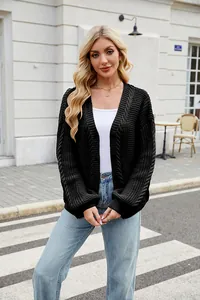 Lifestyle shot of a model wearing a loose black cable-knit cardigan sweater coat
