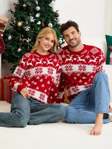 Couple wearing matching red Christmas sweaters with elk and snowflake jacquard patterns