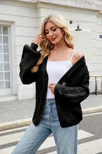 Close-up of a chunky black cable knit cardigan with a relaxed lazy style fit and long sleeves
