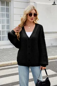 Close-up detail of a stylish black oversized cable-knit cardigan worn by a model outdoors