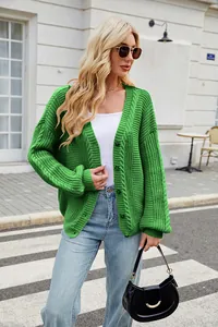 Detailed shot of a green cable-knit V-neck cardigan with relaxed long lantern sleeves.